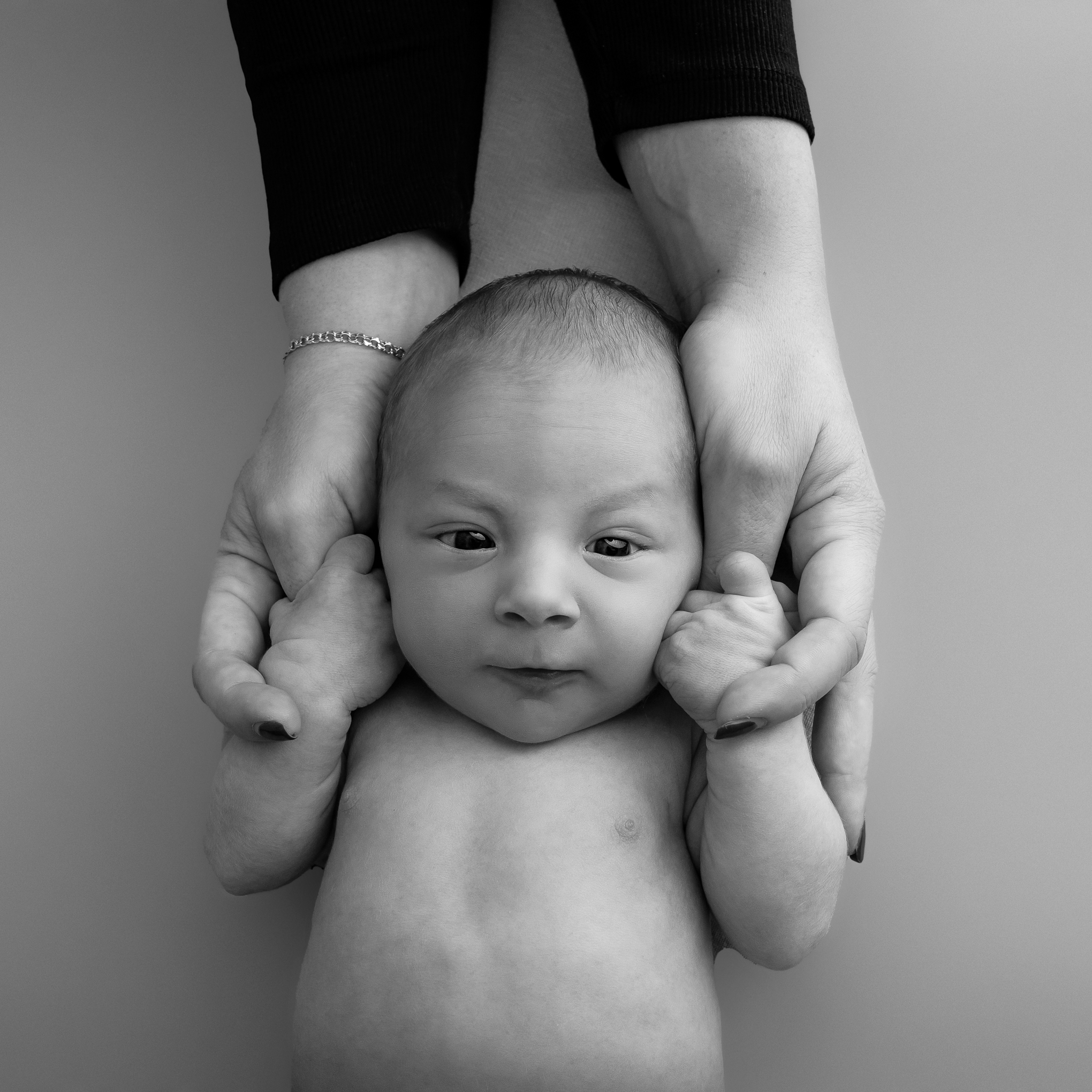 Nyföddfoto av bebis i mammas händer
